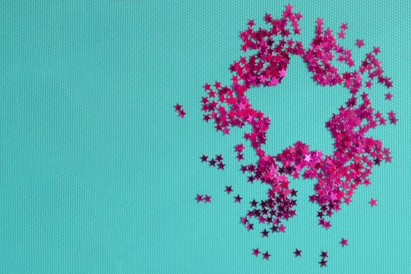 Star of pink stars on a blue background. Inside is empty for text. Flat lay, top view, copy space. Place for your text.