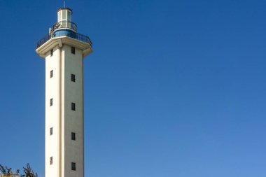 Boş mavi gökyüzü arka plan üzerinde açık bir günde öğle vakti deniz feneri. Bir işaret ile deniz teması duvar kağıdı.