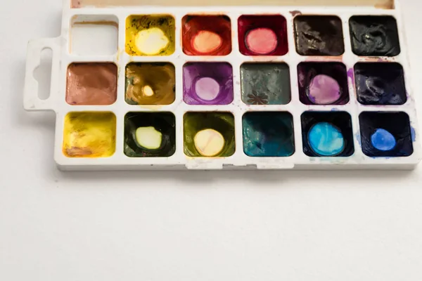 Bright colorful watercolor paints with palette on a white background. Close-up watercolor tray. Flat lay, top view, copy space. School and creativity concept — Stock Photo, Image