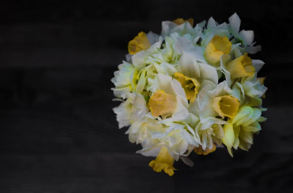 Ein Blumenstrauß auf dunklem Holzgrund. weiße Narzissen in einer Vase. Platz für Ihren Text. Ansicht von oben. — Stockfoto