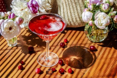 Parlak güneşli bir günde, güneşli bir günde, panjurların çapraz çizgili gölgesinde, ahşap masanın üzerindeki beyaz çiçeklerle çevrili, güz meyveleri ve buzla çevrili, bir bardak kırmızı içecekle kırsal sakin bir hayat. Tebrik kartı