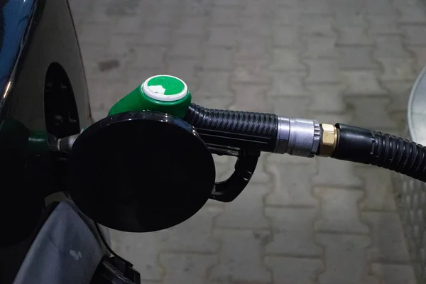 close up fueling gun in a dark car gas tank