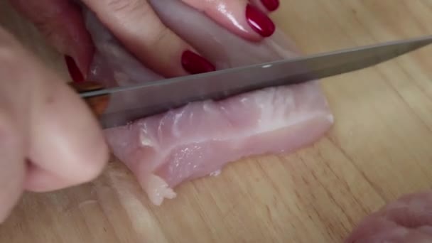 女人与红色指甲特写慢慢削减鸡在板 — 图库视频影像