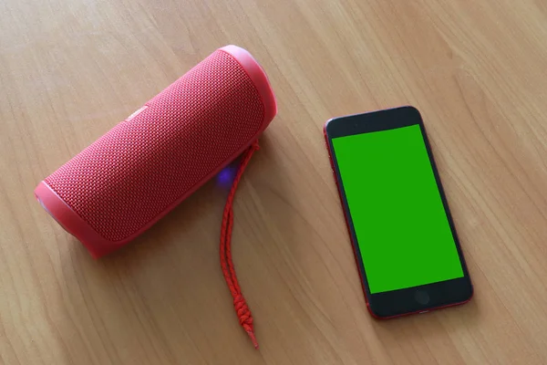 Téléphone Avec Écran Vert Haut Parleur Bluetooth Sur Une Table — Photo