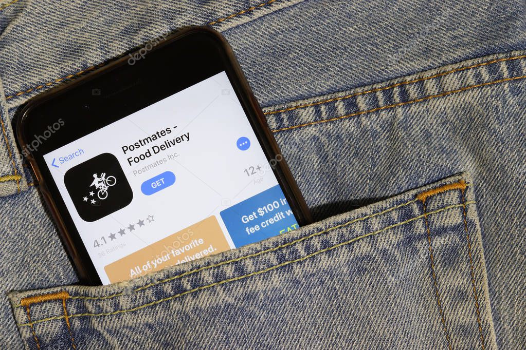Los Angeles, California, USA - 10 October 2019:  Mobile phone with Postmates icon on App Store, logo on screen close up in the blue jeans pocket, Illustrative Editorial