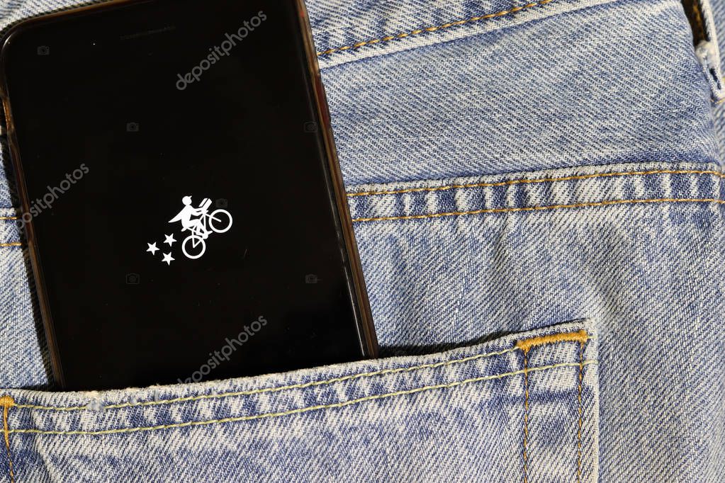 Los Angeles, California, USA - 10 October 2019:  Mobile phone with Postmates - Food Delivery logo on screen in the blue jeans pocket, Illustrative Editorial