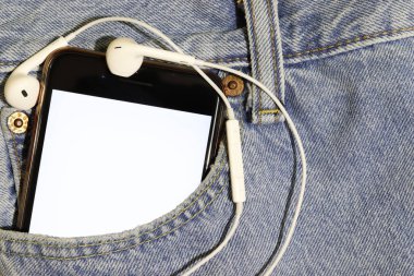 Görsel-işitsel içerik şablonu. Bir podcast veya şarkı illüstrasyonu eklenecek yer. Beyaz ekranlı akıllı telefon ve mavi kot pantolon cebinde kulaklıklar..