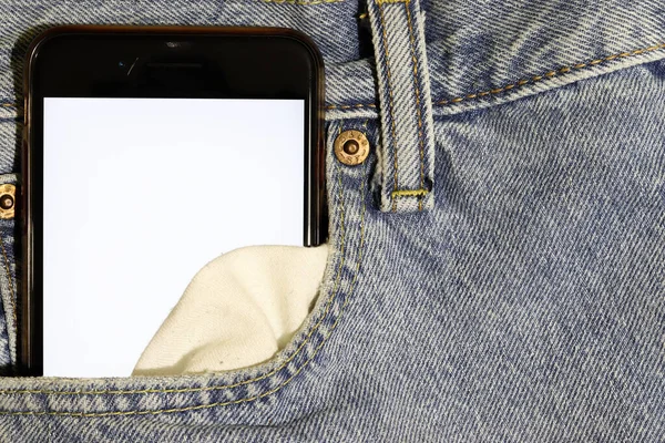 Mock up white screen phone peeping out of the pocket of light blue jeans. Template for design. Denim. Casual use of mobile content. Free space for text or advertisement