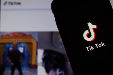 Ekranda Tiktok logosu olan cep telefonu bilgisayarda web sitesini kapat. Tik Tok 'un geçmişi bulanık. Los Angeles, California, Usa - 27 Ekim 2019, Illustrative Editorial