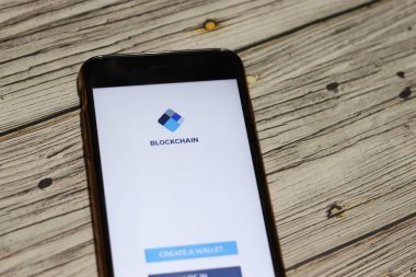 Blockchain Cüzdanı olan cep telefonu ekranı: Bitcoin logosu tahta masaya yakın ve bokeh etkisi yapıyor. Los Angeles, California, Usa - 27 Ekim 2019, Illustrative Editorial