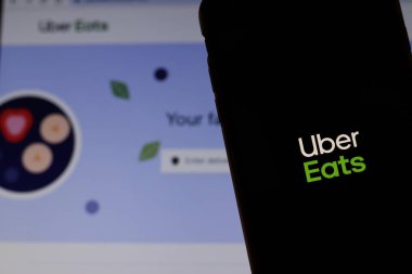 Ekranda Uber Eats logosu olan cep telefonu, dizüstü bilgisayarında web sitesi olan yakın plan. Uber Gıda Teslimatı ile geçmişi bulanık. Los Angeles, California, Usa - 27 Ekim 2019, Illustrative Editorial