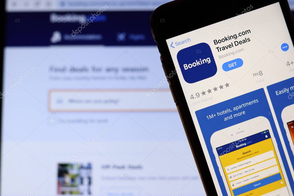 Mobile phone with Booking logo on screen close up with website on laptop. Blurred background with Booking.com. Los Angeles, California, USA - 27 October 2019, Illustrative Editorial