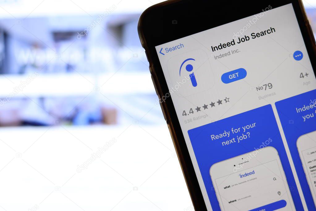 Mobile phone with Indeed icon on screen close up with website on laptop. Blurred background with Indeed Job Search site. Los Angeles, California, USA - 27 October 2019, Illustrative Editorial