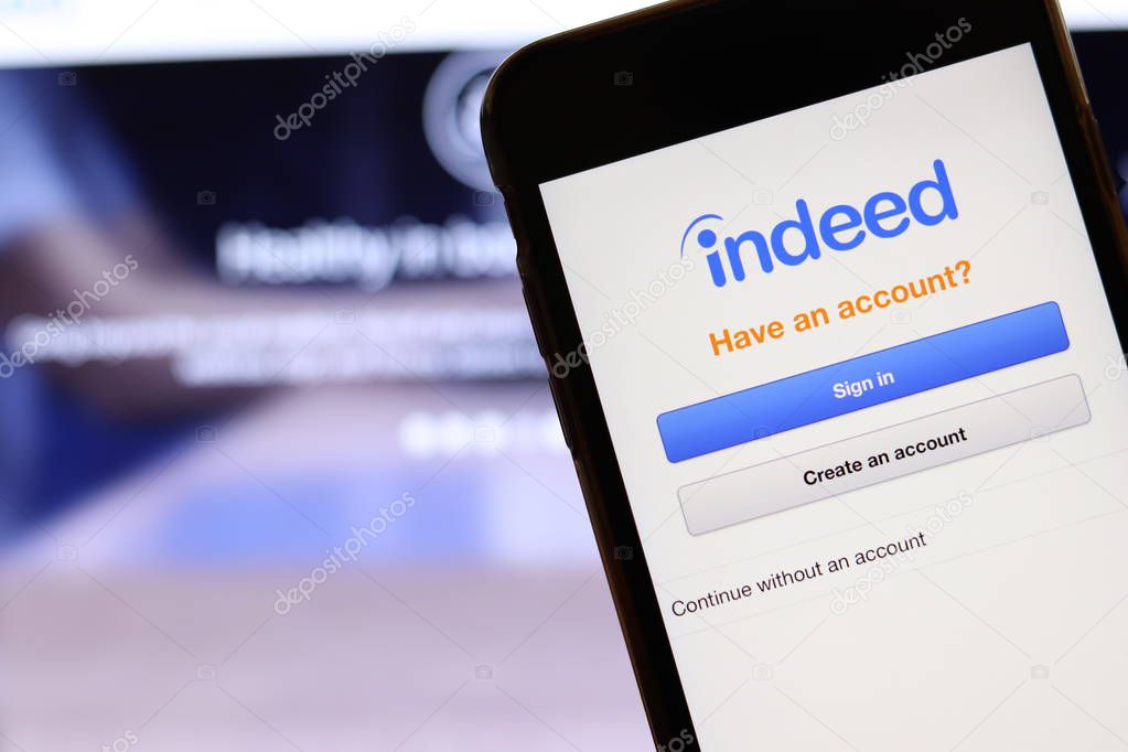 Mobile phone with Indeed logo on screen close up with website on laptop. Blurred background with Indeed Job Search site. Los Angeles, California, USA - 27 October 2019, Illustrative Editorial