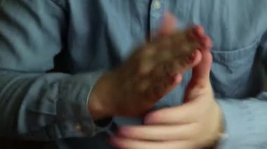 Adam hızlı bir şekilde ellerini topraktan sallıyor.