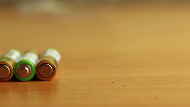 Les piles AA qui roulent autour de la table se ferment. Fond flou. Concept de recyclage et d'élimination