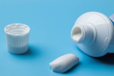 Sabah hijyeni ve kişisel bakım konsepti. Mavi arkaplanda diş macunu yakın plan.