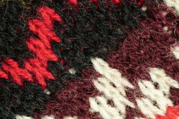 Black, red and white fur tissue texture. Wool cloth background.