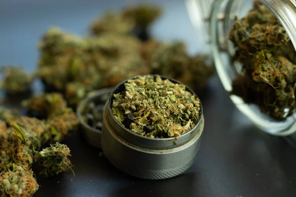 医療目的で大麻を合法的に使用する マリファナの芽の背景 粉砕機と瓶の中の雑草は閉じる — ストック写真