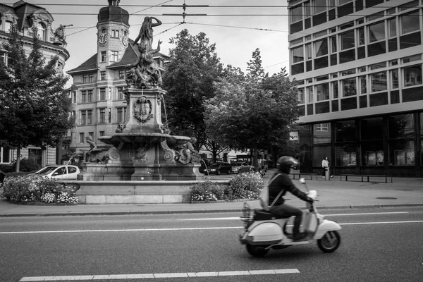 İsviçre, St. Gallen 'de bir çeşmenin önünde scooter.