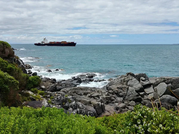Bir konteyner gemisi Bluff, Yeni Zelanda limanının ayrılıyor