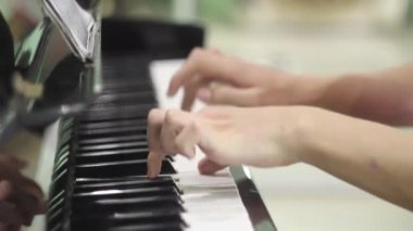 Genç adam piyano çalıyor. Eller yakın. müzik enstrüman üzerinde egzersizleri. klavye müzik aleti. salfegio için. bir müzisyenin uzun parmakları. okulda müzik eğitimi.
