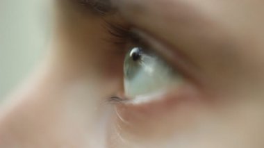 yanıp sönen erkek gözü yakın. dalgın üzgün makro bakmak. Bulanık arka planda bir adamın yarısı yüzü, yan görüş. göz küresi üzerinde kırmızı arterler. copyspace.