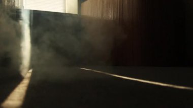 odadaki duman güneş ışığı şeridi boyunca zemin boyunca yayılır. gün ortasında dairede yangın başlangıcı.