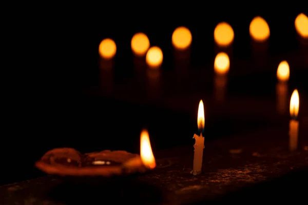 Beleuchtete Kerze und Diya auf schwarzem Hintergrund — Stockfoto