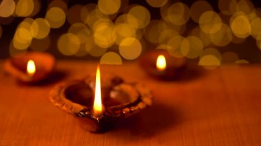Diya ya da Diwali gecesinde tahta bir yüzey üzerinde fotokopi alanı olan güzel bir bokeh arka planı olan kil lambaları. Geleneksel kil yağ lambalarının video görüntüleri veya diya.