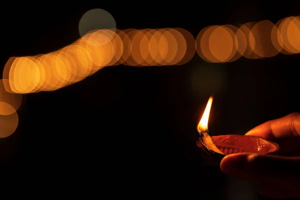 Männliche Hand hält diwali diya bei festlicher Nacht — Stockfoto
