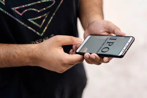 Halka arz kavramı. Hintli işçi el ele tutuşmuş akıllı telefon & İlk Kamu Teklifi 'ni gösteriyor. Ekranında görüntüleniyor. Kopya alanı ile beyaz arkaplanda izole edilmiş..