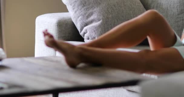 Mujer embarazada sonriente acostada en el sofá tocando su vientre — Vídeos de Stock