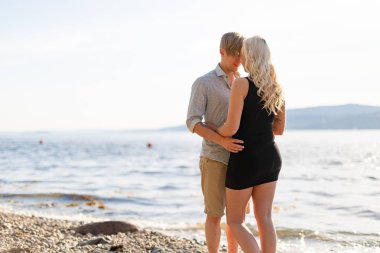 Güzel genç çift, yaz sahilde romantik kucaklama içinde