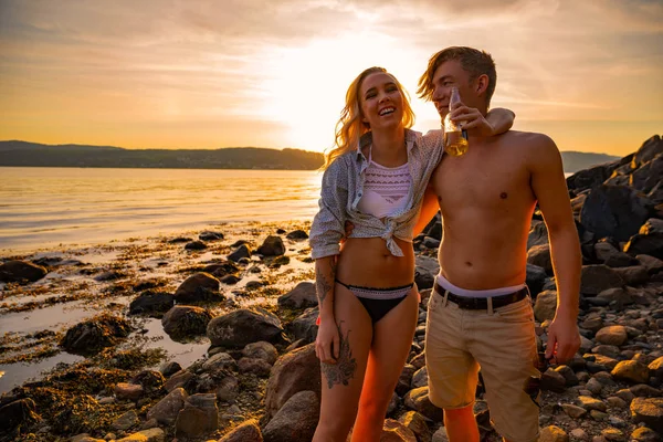 Couple heureux s'amuser et boire de la bière à la plage — Photo