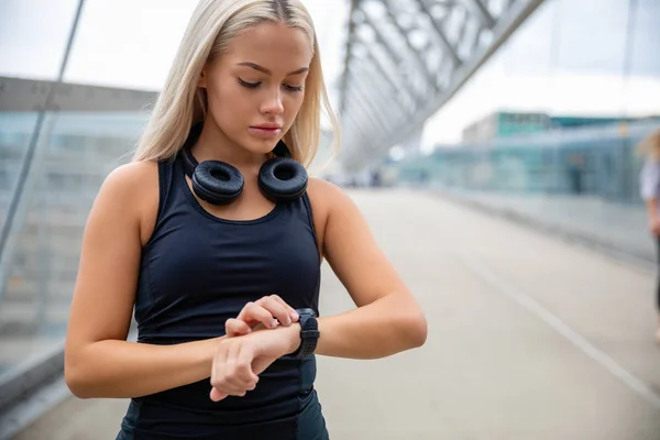 Frau überprüft Herzfrequenz per Smartwatch nach dem Training — Stockfoto
