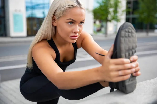 Решительная женщина делает упражнения на растяжку на тротуаре Railing — стоковое фото