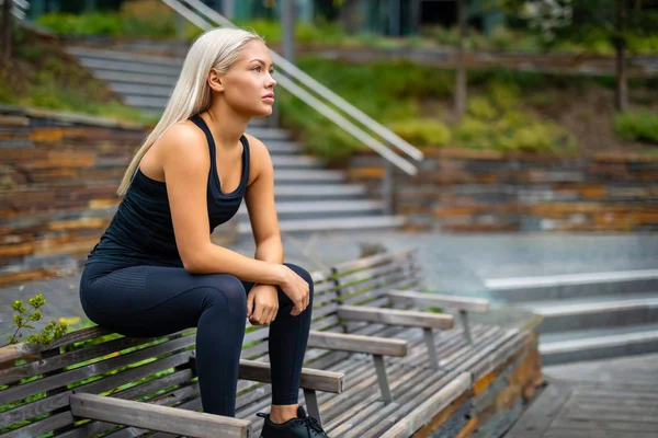 Tankeväckande löpare sitter på bänken efter träningspass — Stockfoto