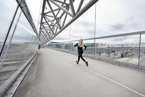 Спортивная молодая женщина быстро бегает в городской среде — стоковое фото