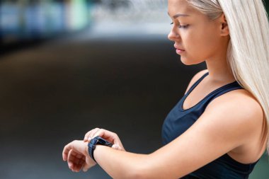 Kadın Runner Road üzerinde çalışmadan sonra SmartWatch kontrol