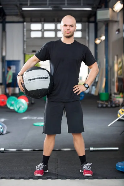 Deportista masculino determinado sosteniendo balón de la medicina en el club de salud —  Fotos de Stock