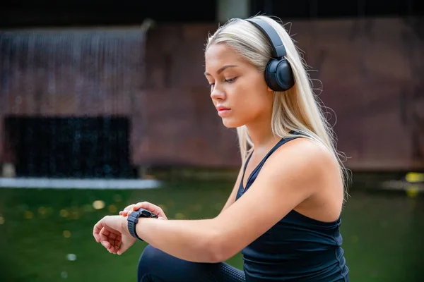 Deportiva corredor femenino escuchar música en los auriculares mientras se utiliza S —  Fotos de Stock