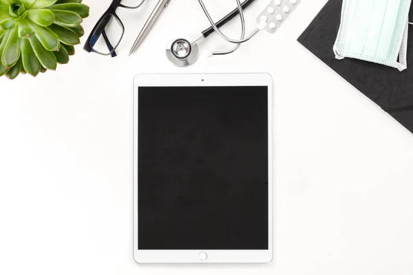 Tableta digital con pantalla en blanco y equipo médico en la mesa — Foto de Stock