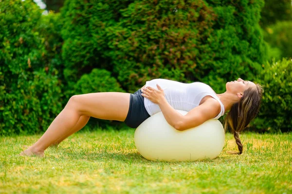 Pregnant Woman Stretching Back On Yoga Ball In Park — Stock Photo, Image