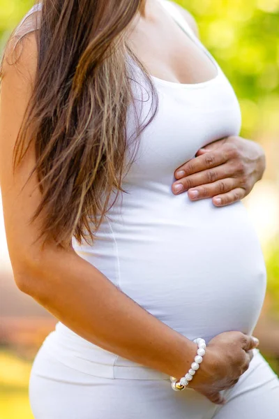 Gros plan de la femme enceinte debout en plein air tenant la main sur le ventre — Photo