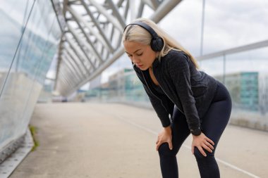 İle dinlenme yorgun kadın Runner diz egzersiz yaptıktan sonra eller.