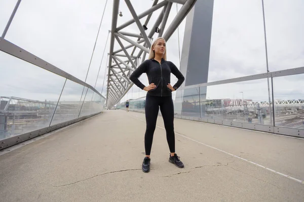 Beautiful and Confident Blonde Woman with Hands on the Hips in Workout Outfit