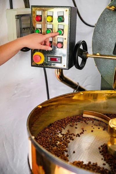Женские ручки жаровня в производстве органического кофе — стоковое фото
