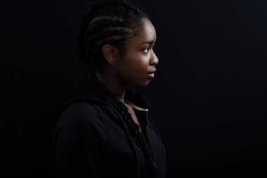 Serin ve güzel Siyah Kadın Model Siyah Arka Plan Karşı Looking Away