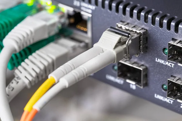 Close-up of high speed fiber network switch and cables in datacenter